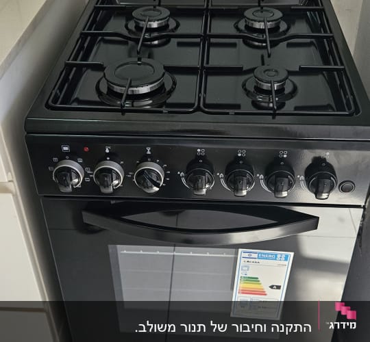 תנור גז שחור עם ארבעה מבערים וכפתורי שליטה
